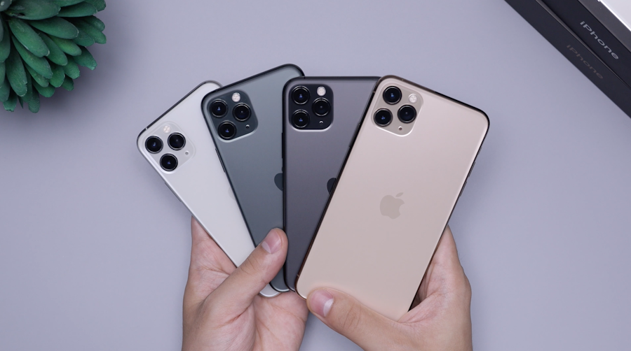Several iPhones in different colors held in hand